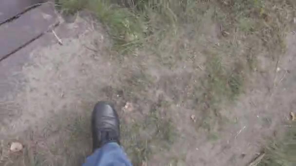男性腿 蓝色牛仔裤 黑色的鞋子沿着小路走 那个人走着 第一人称视图 4K视频 — 图库视频影像