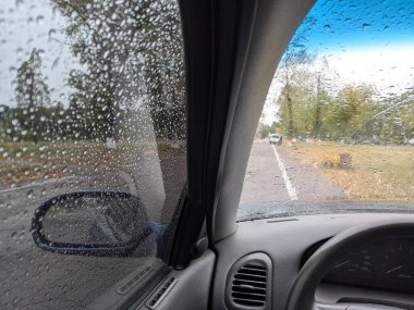 Arabanın camında yağmur damlaları var. Yağmurda arabanın içinde. otomatik sonbahar yağmuru