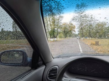 Arabanın camında yağmur damlaları var. Yağmurda arabanın içinde. otomatik sonbahar yağmuru