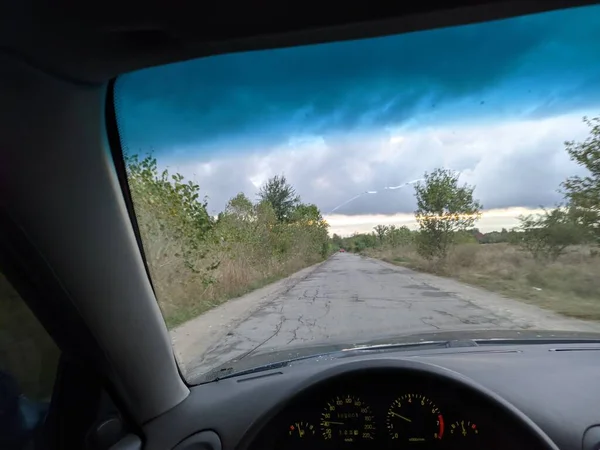 在多云的天气里 在车里 司机在方向盘后面 能见度低 打开挡风玻璃 — 图库照片