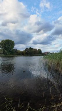 Su ve kasvetli gökyüzü manzarası. Mavi gökyüzünde manzaralı beyaz bulutlarla mükemmel derin mavi denizin üzerinde destansı bir uçuş. Uzakta görülen sonsuz ufuk. Suyun aktığı sakin nehir sahnesi.
