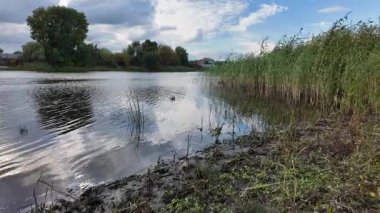 Su ve kasvetli gökyüzü manzarası. Mavi gökyüzünde manzaralı beyaz bulutlarla mükemmel derin mavi denizin üzerinde destansı bir uçuş. Uzakta görülen sonsuz ufuk. Suyun aktığı sakin nehir sahnesi.