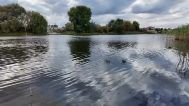 Su ve kasvetli gökyüzü manzarası. Mavi gökyüzünde manzaralı beyaz bulutlarla mükemmel derin mavi denizin üzerinde destansı bir uçuş. Uzakta görülen sonsuz ufuk. Suyun aktığı sakin nehir sahnesi.