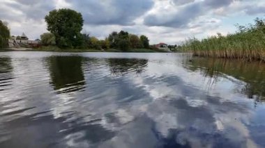 Su ve kasvetli gökyüzü manzarası. Mavi gökyüzünde manzaralı beyaz bulutlarla mükemmel derin mavi denizin üzerinde destansı bir uçuş. Uzakta görülen sonsuz ufuk. Suyun aktığı sakin nehir sahnesi.