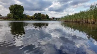 Su ve kasvetli gökyüzü manzarası. Mavi gökyüzünde manzaralı beyaz bulutlarla mükemmel derin mavi denizin üzerinde destansı bir uçuş. Uzakta görülen sonsuz ufuk. Suyun aktığı sakin nehir sahnesi.