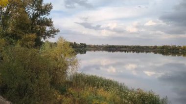 Su ve kasvetli gökyüzü manzarası. Mavi gökyüzünde manzaralı beyaz bulutlarla mükemmel derin mavi denizin üzerinde destansı bir uçuş. Uzakta görülen sonsuz ufuk. Suyun aktığı sakin nehir sahnesi.