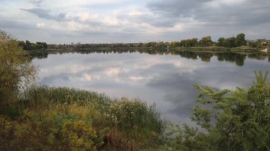 Su ve kasvetli gökyüzü manzarası. Mavi gökyüzünde manzaralı beyaz bulutlarla mükemmel derin mavi denizin üzerinde destansı bir uçuş. Uzakta görülen sonsuz ufuk. Suyun aktığı sakin nehir sahnesi.