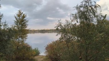 Su ve kasvetli gökyüzü manzarası. Mavi gökyüzünde manzaralı beyaz bulutlarla mükemmel derin mavi denizin üzerinde destansı bir uçuş. Uzakta görülen sonsuz ufuk. Suyun aktığı sakin nehir sahnesi.