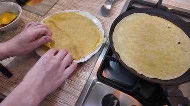 Kızartma tavasında gözleme. Yetenekli bir şef lezzetli bir krep pişirir, tavada kızartır, yakın plan, kırpılmış yan görüş, yavaş çekim. Bir adam evde krep kızartır. Şeye göre yemek pişirmek...