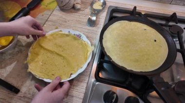 Kızartma tavasında gözleme. Yetenekli bir şef lezzetli bir krep pişirir, tavada kızartır, yakın plan, kırpılmış yan görüş, yavaş çekim. Bir adam evde krep kızartır. Şeye göre yemek pişirmek...