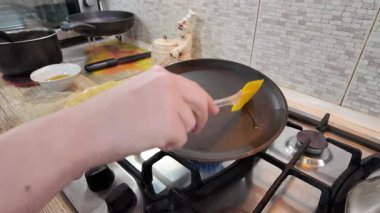 Kızartma tavasında gözleme. Yetenekli bir şef lezzetli bir krep pişirir, tavada kızartır, yakın plan, kırpılmış yan görüş, yavaş çekim. Bir adam evde krep kızartır. Şeye göre yemek pişirmek...