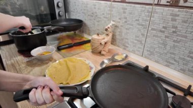 Kızartma tavasında gözleme. Yetenekli bir şef lezzetli bir krep pişirir, tavada kızartır, yakın plan, kırpılmış yan görüş, yavaş çekim. Bir adam evde krep kızartır. Şeye göre yemek pişirmek...
