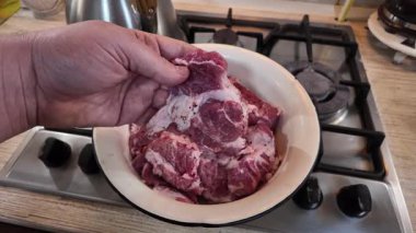 Bir şef elinde bir biftek tutar. Et kırıntısı. Ev yemeği. Evde et pişiriyorum. Yavaş çekim videosu. Tahta kesme tahtasıyla lezzetli bir bifteği dilimleyen bir adamın yakın çekimi..