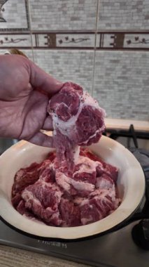 Bir şef elinde bir biftek tutar. Et kırıntısı. Ev yemeği. Evde et pişiriyorum. Yavaş çekim videosu. Tahta kesme tahtasıyla lezzetli bir bifteği dilimleyen bir adamın yakın çekimi..