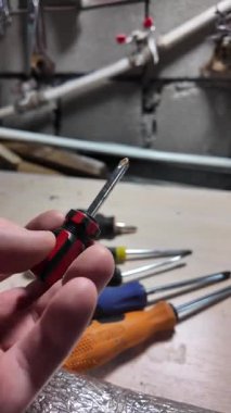 Tornavida elinde. Kapalı alanda DIY ahşap mobilya monte ederken, siyah erkek eli tornavidayla vidaları tamir ederken yakın plan. Küçük Tornavidalar.