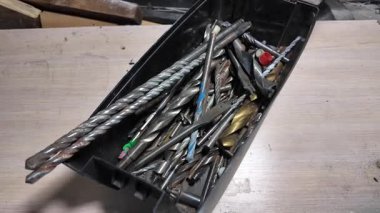 Matkap uçları. Elektrikli matkapla beyaz bir duvarı delmeye yakın plan. İnşaata odaklan. İnşaat, yenileme, DIY projeleri, inşaat aracı reklamcılığı, eğitim.