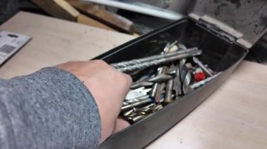 Matkap uçları. Elektrikli matkapla beyaz bir duvarı delmeye yakın plan. İnşaata odaklan. İnşaat, yenileme, DIY projeleri, inşaat aracı reklamcılığı, eğitim.