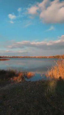 Beautiful autumn landscape with a lake and blue water. Landscape in cinematic colors. Sunset on the lake. 4K 60fps.