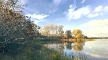Beautiful autumn landscape with a lake and blue water. Retro-style landscape. Unusual colors. Sunset on the lake. 4K 60fps.