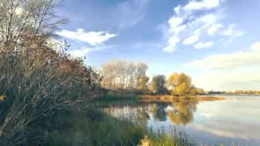 Beautiful autumn landscape with a lake and blue water. Retro-style landscape. Unusual colors. Sunset on the lake. 4K 60fps.