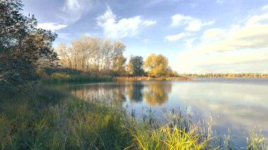 Beautiful autumn landscape with a lake and blue water. Retro-style landscape. Unusual colors. Sunset on the lake. 4K 60fps.