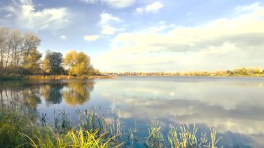 Beautiful autumn landscape with a lake and blue water. Retro-style landscape. Unusual colors. Sunset on the lake. 4K 60fps.