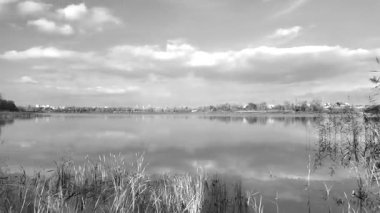Beautiful autumn landscape with a lake and blue water. Retro-style landscape. Black and white landscape. Unusual colors. Sunset on the lake. 4K 60fps.