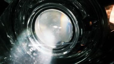 Gece parlak bir şekilde parlayan bir araba farının yakın çekimi yansıtıcı camlar, LED ışınlar ve sinyal aydınlatması sergiliyor. Karanlık bir ortamda dramatik bir otomotiv aydınlatma detayı.