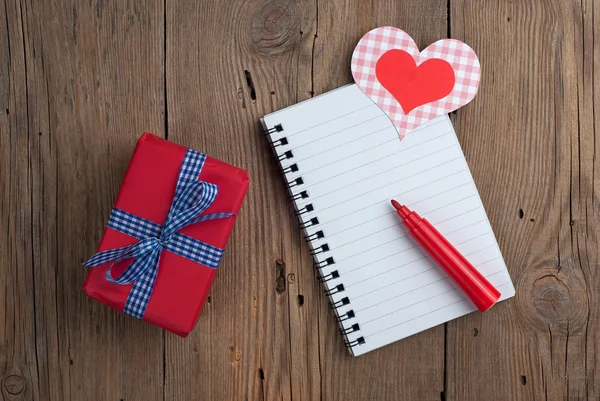 Cuaderno con regalo, rotulador y corazones — Foto de Stock