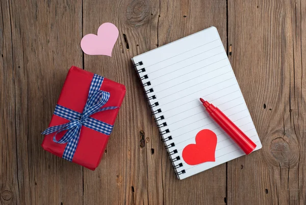 Quaderno con regalo, pennarello e cuori — Foto Stock