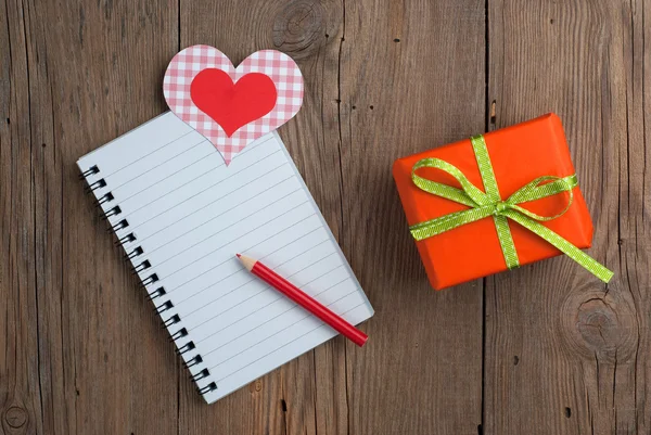 Quaderno con regalo, matita e cuori — Foto Stock