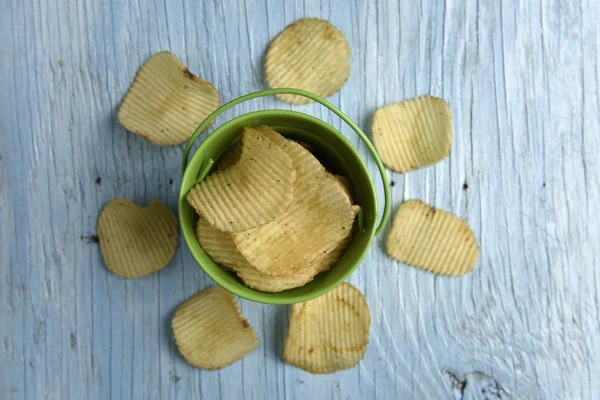 Patatas fritas en un cubo sobre una vieja mesa de madera — Foto de Stock