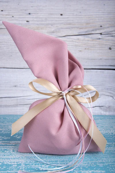 Fabric pouch tied with ribbon on old wooden table — Stock Photo, Image