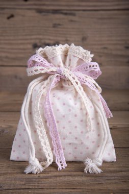 Eski ahşap masa üstünde kurdele ile bağlanmış kumaş çanta