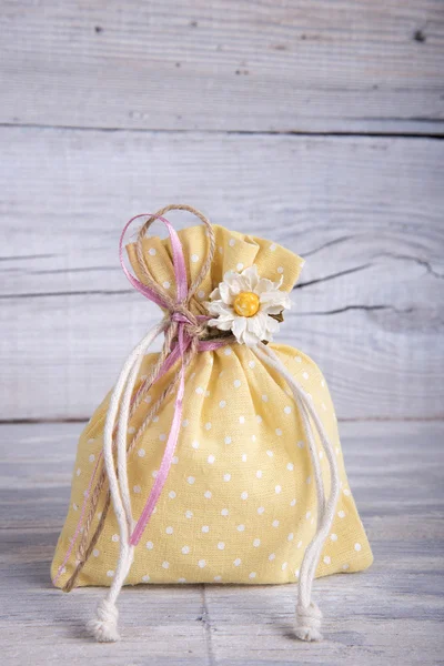 Bolsa de tecido amarrada com fita na mesa de madeira velha — Fotografia de Stock