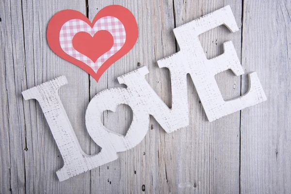 Slovo láska a papírové srdce — Stock fotografie