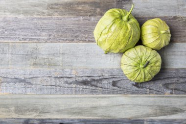 Ahşap masa üzerinde üç Tomatillos