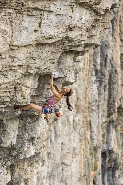 Rock klimmer klampt zich vast aan een klif. — Stockfoto