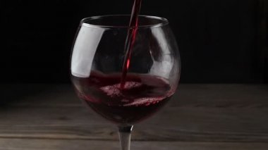 kırmızı şarap bardağa dökülüyor..