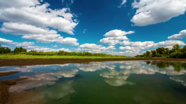 Zeitraffer mit fließenden Wolken mit Reflexion im Wasser und tiefblauem Himmel — Stockvideo