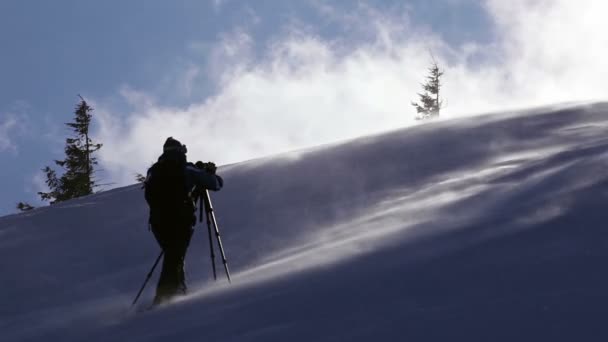 Фотограф работает в зимних горах — стоковое видео