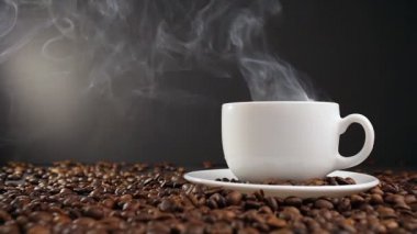 Kupası ile kavrulmuş kahve çekirdeği üzerinde sıcak içecek. dolly vurdu