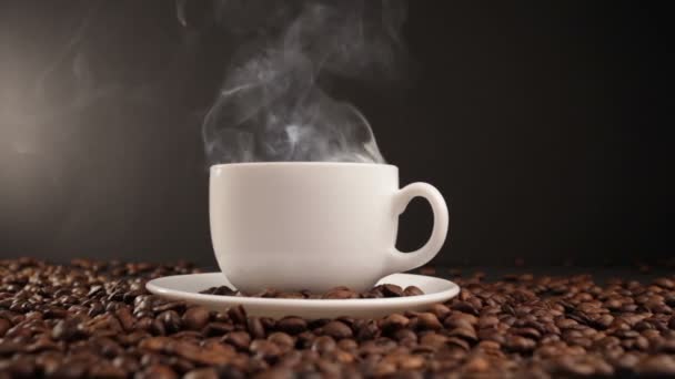 Tasse avec boisson chaude sur grains de café torréfiés. Dolly shot — Video