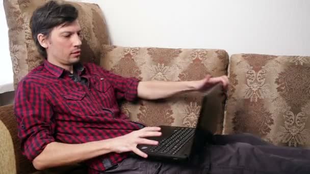 Uomo sdraiato che lavora sul computer portatile — Video Stock