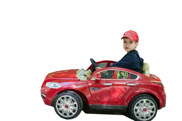 Çocuk beyaz bir arka plan üzerinde izole kırmızı araba sürmek — Stok fotoğraf