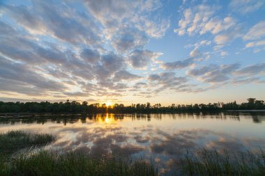 Güzel gün batımı nehirde yansıyan.