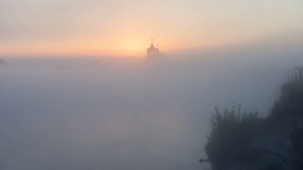 Sonnenaufgang am Fluss in der Nähe der Kirche — Stockvideo