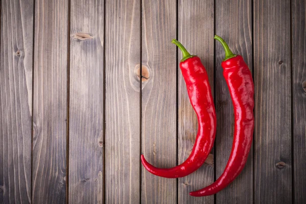 Pimientos rojos picantes sobre fondo de madera — Foto de Stock