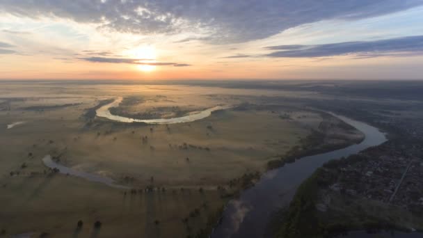 Вид с воздуха на впечатляющий пейзаж с рекой, проходящей через долину под низкими лучами солнца — стоковое видео