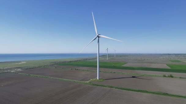 Větrná turbína na venkově v létě slunečný den pod jasnou oblohou — Stock video